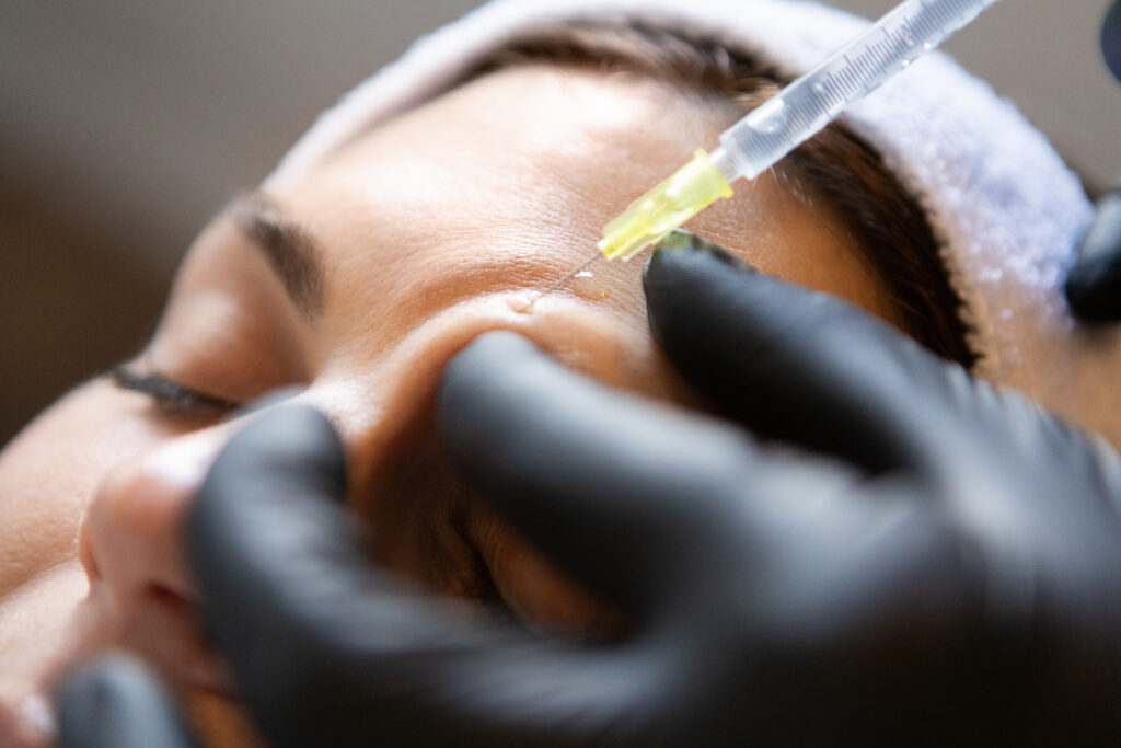 Dermatologists applying Botox to her patients face
