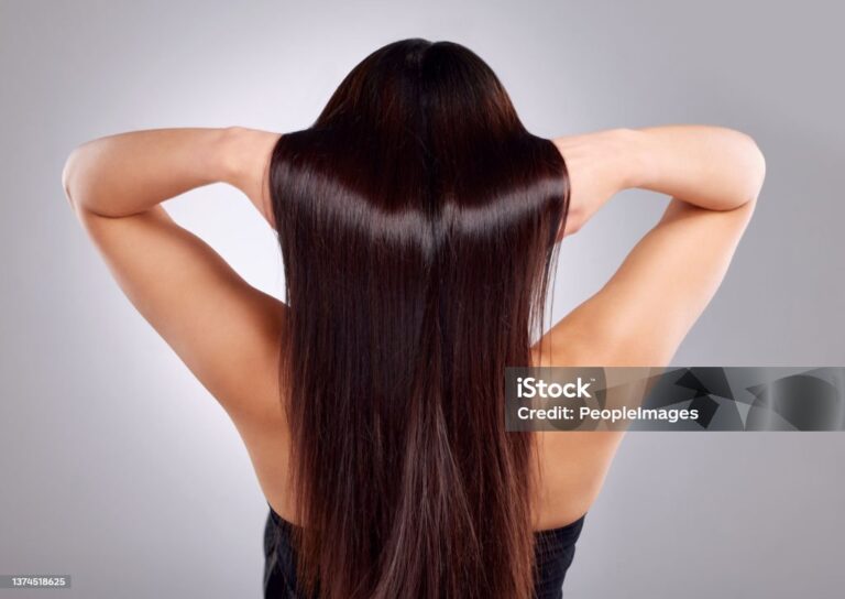 Woman with smooth long hair viewed as healthy shiny hair post hair restoration