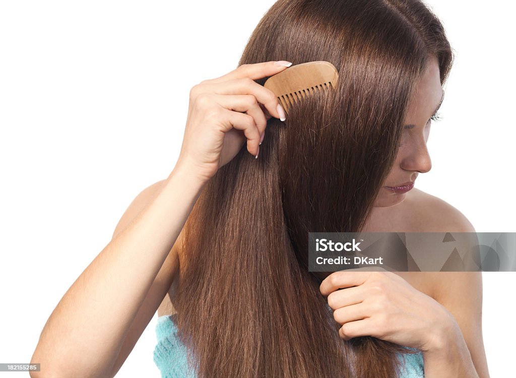 Woman brushing long smooth brown hair for hair restoration therapy